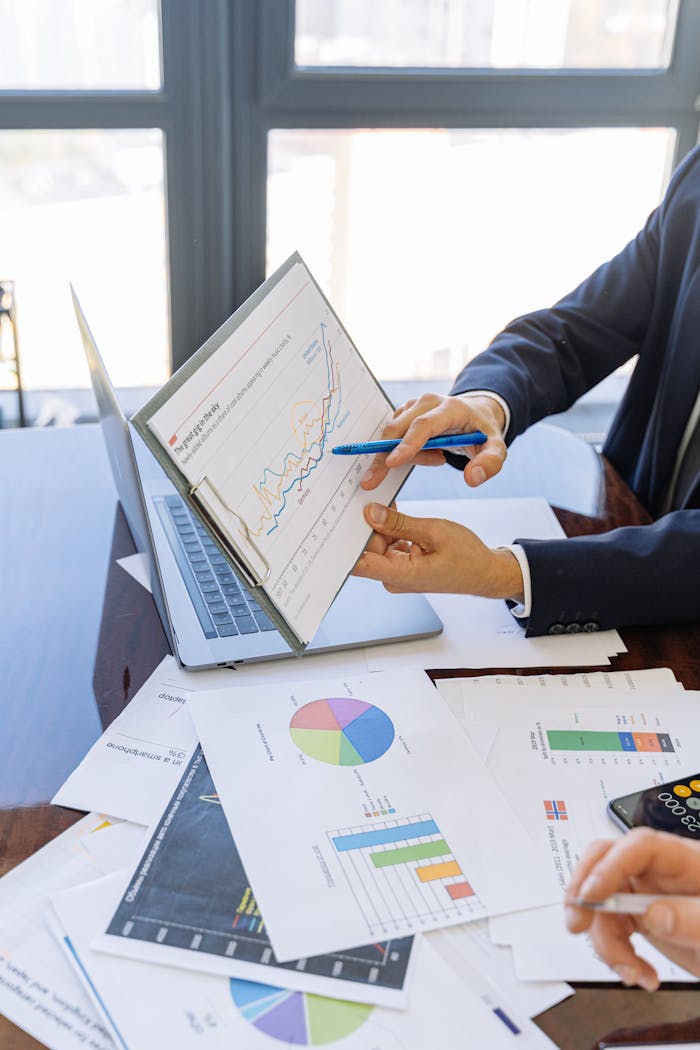 why-choose-us Business professionals discussing financial graphs and charts in an office setting.